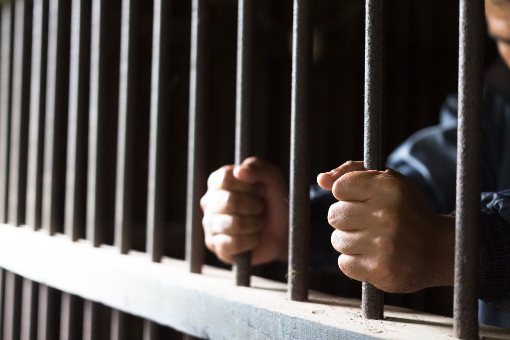 inmate holding prison bars