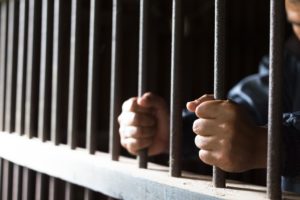 inmate holding prison bars