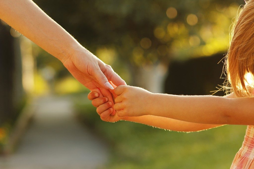 a child holding their parent's hand