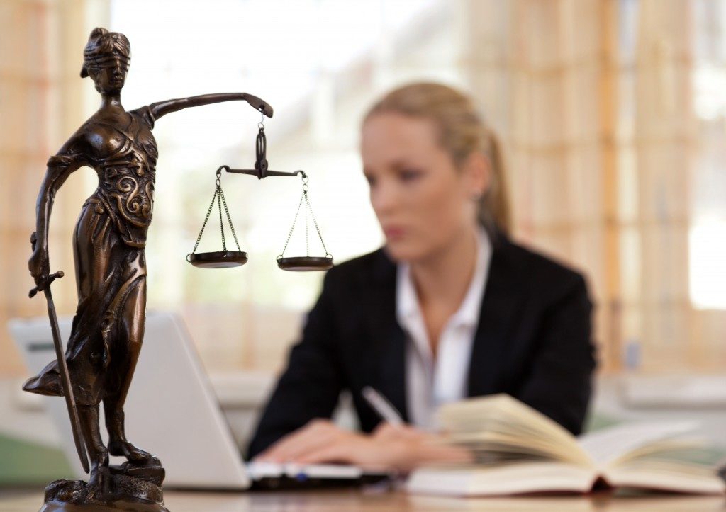 Photo of lady justice with court reporter behind