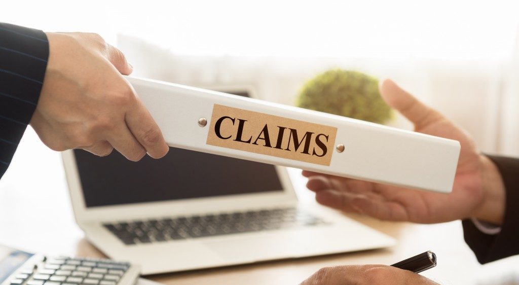 person handing over a claims book to another