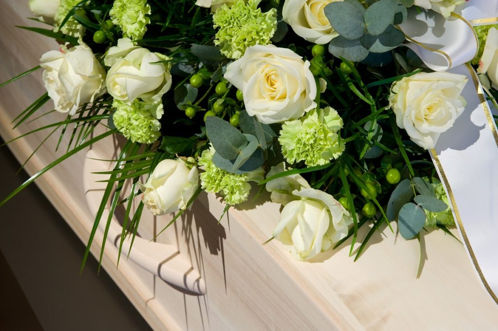 Coffin with white roses