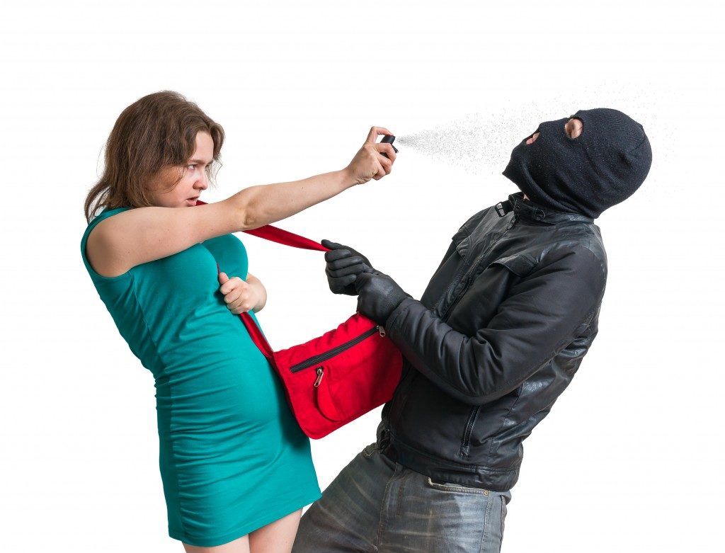 Woman using pepper spray against thief