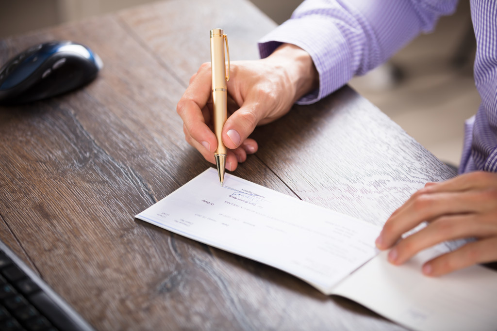 a person writing on a cheque