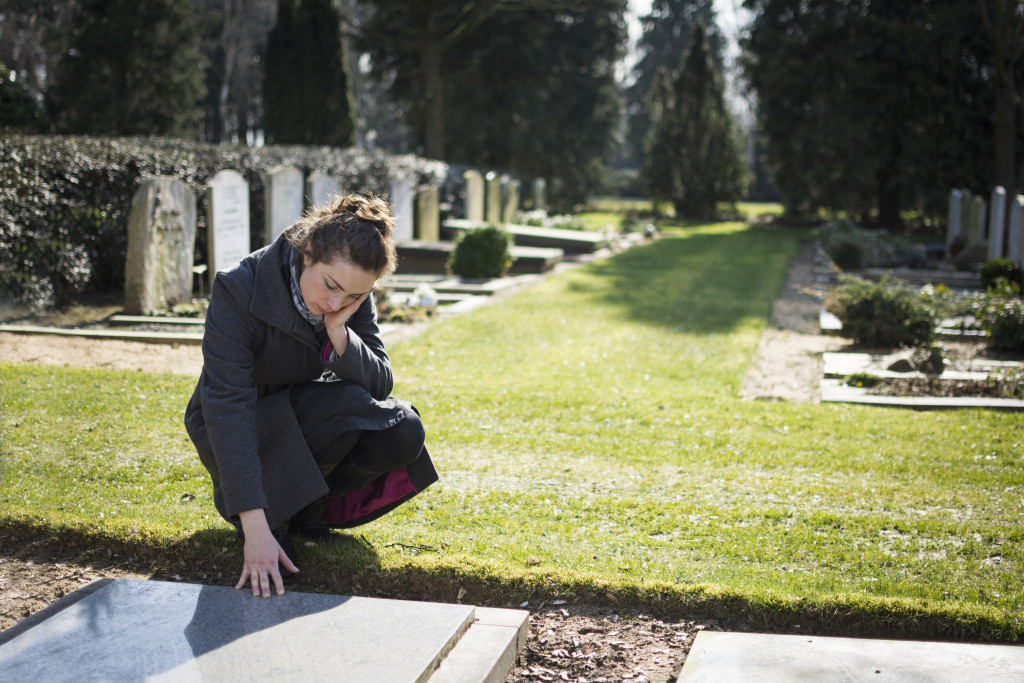 A friend visiting a departed loved one's grave