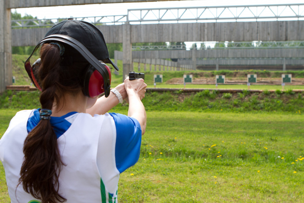 Woman shooting at targets at an outdoor firing range.