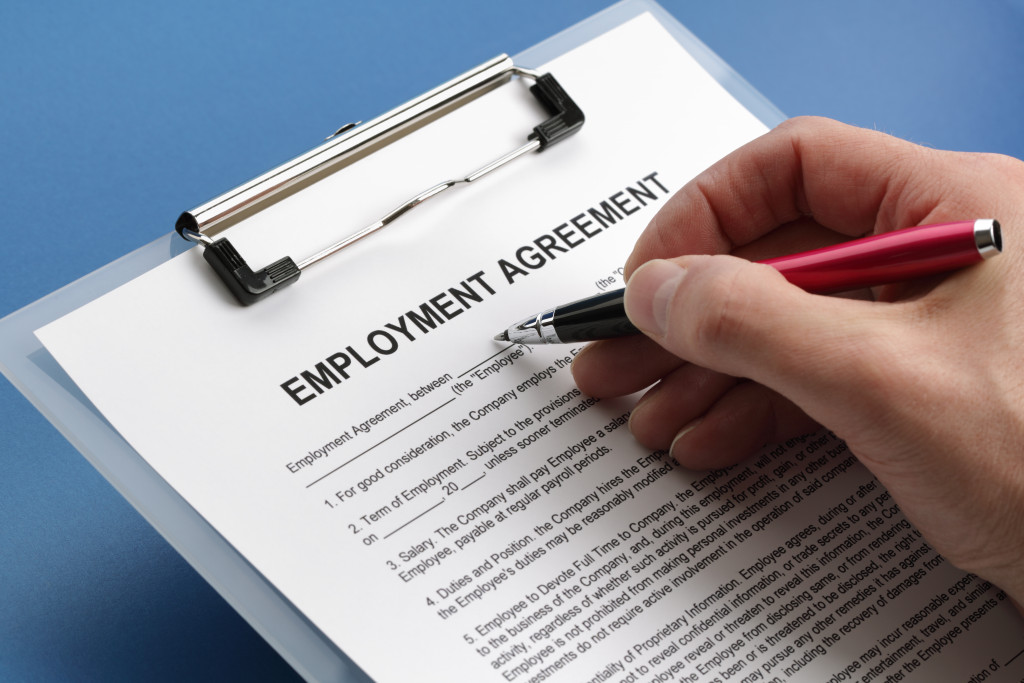 employment agreement being signed by person using red pen
